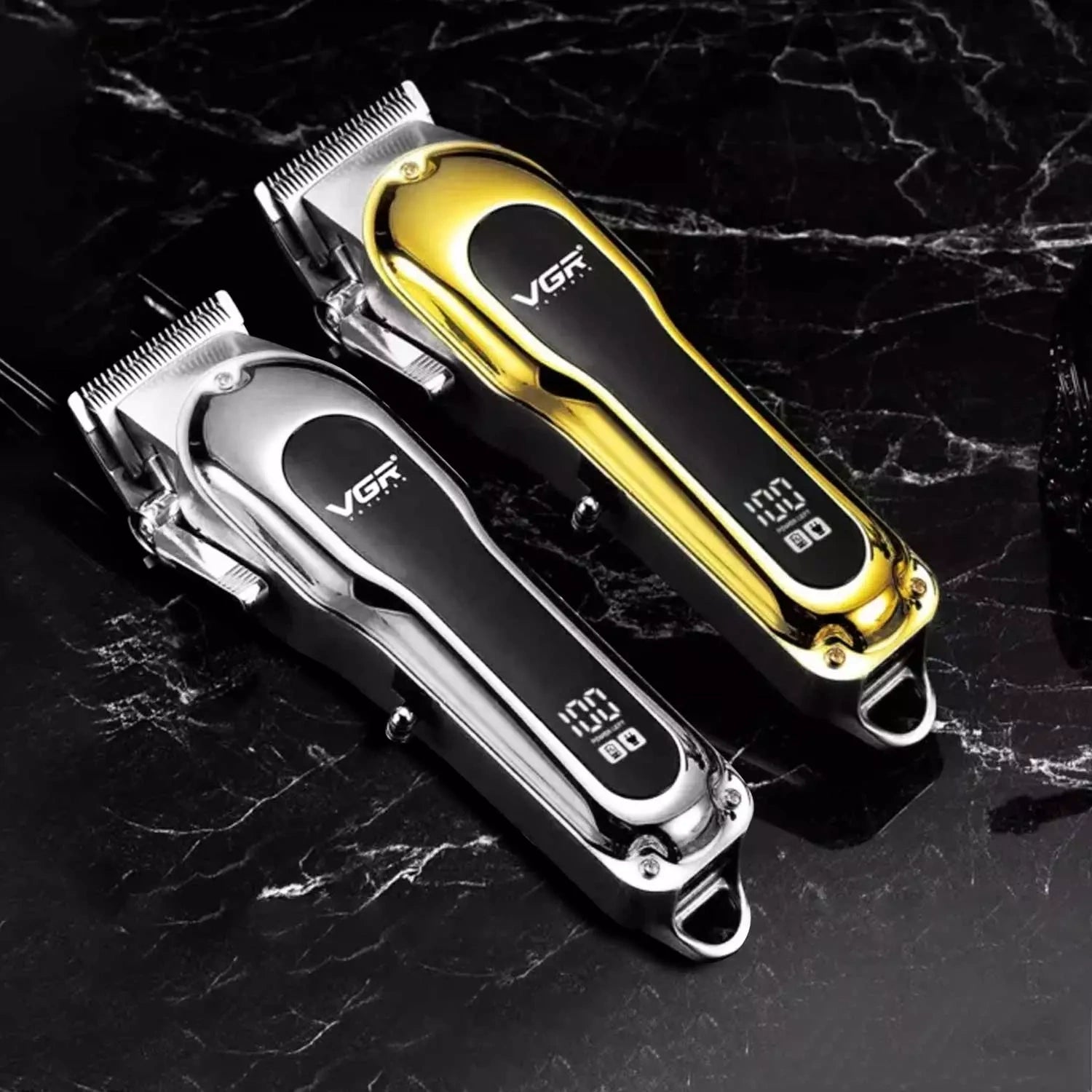 Two VGR V-680 hair clipper trimmers, one silver and one gold, with LED displays, placed on a dark marble surface.