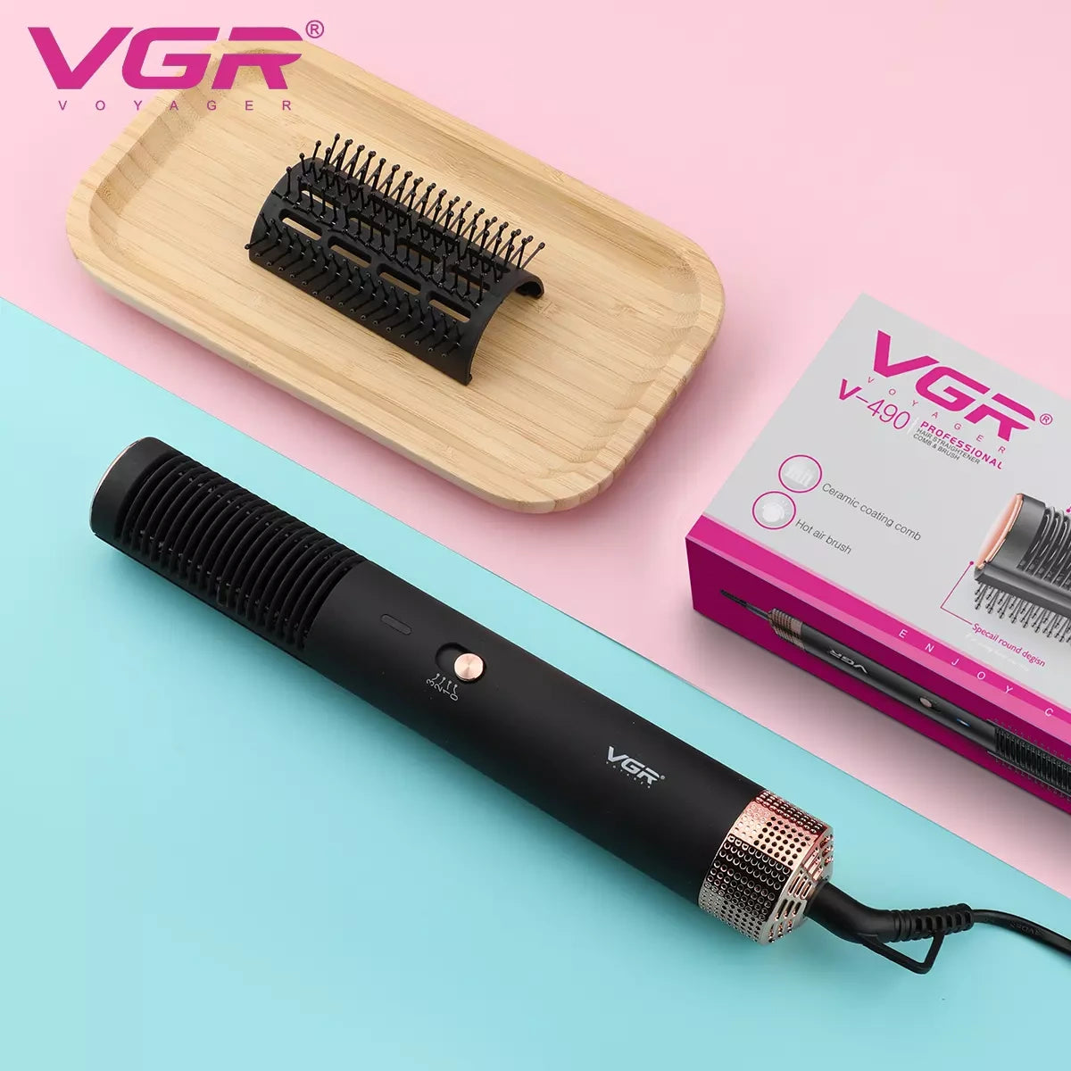 A black VGR V-490 hot air brush for women, displayed alongside its packaging and a wooden hair comb attachment, against a pink and blue background.